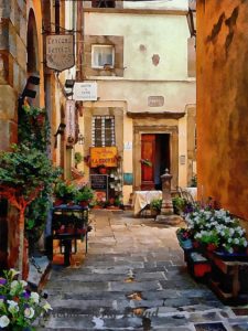 An Italian courtyard scene. We look down a flagstone path, past various containers planted with flowering plants, many of them white flowers. It is nice and shady and the buildings are dark sand coloured. As we look further into the centre of the image we see a courtyard in full sunshine with a table, with a tablecloth, and chairs, just behind a water station. Beyond the table there is a half open wooden door in a white building. There is a sign for a restaurant. It looks very inviting.