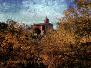 An impressionist style photo painting of a beautiful autumn dusk and the last rays of sunshine fall on the trees in the foreground that are in full autumn colour. Behind the trees, on a small hillside is a church with a belltower. The sky is a mix of shades of blue.